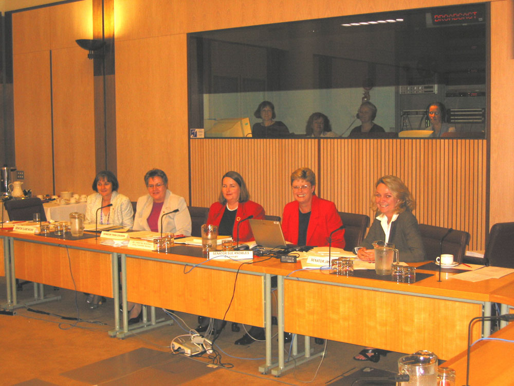 Members of the Community Affairs Legislation Committee during a historic supplementary budget estimates hearing on 21 November 2002 in which all participants, including the officers, minister and secretary of the Department of Health and Ageing, were female. In box L-R: Meryl Hampson [Hansard editor], Trish Reeves [Hansard monitor], Trish Schumacher [Hansard editor] and Emma Flett [Broadcasting technician]. At table L-R: Senators Claire Moore and Trish Crossin, Christine McDonald [Acting Secretary], Senators Sue Knowles and Jan McLucas.