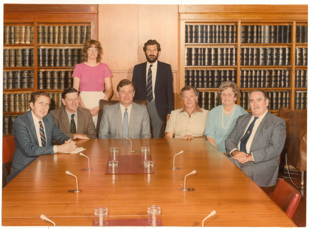Standing Committee on National Resources, 1982. Standing L-R: Jane Palmer [Research Officer] and Derek Abbott [Secretary]. Seated L-R: Senators Michael Tate, John Watson, Andrew Thomas [Chair], Geoff McLaren [Deputy Chair], Florence Bjelke-Petersen and Ted Robertson.