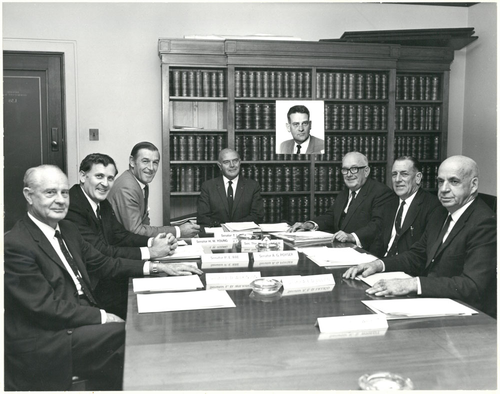 Standing Committee on Primary and Secondary Industry and Trade, April 1971. Inset: Senator Ken Wriedt. Seated L-R: Senators Laurie Wilkinson, Peter Rae, Harold Young, Tom Bull [Chair], Vincent Gair, George Poyser and Alexander Lillico.