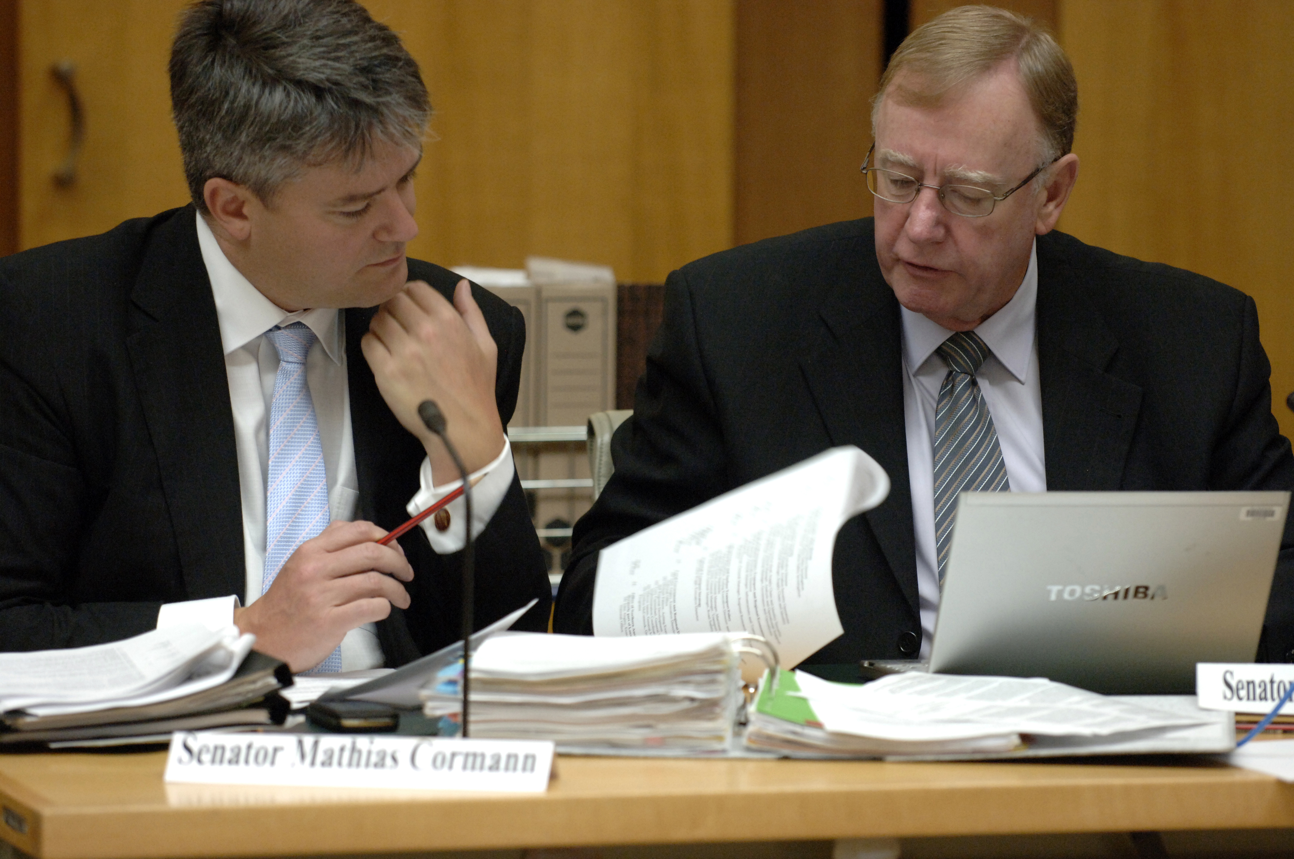 Committee members Senators Mathias Cormann and Ian Macdonald examining documents, additional estimates hearing, 24 February 2009. DPS Auspic.