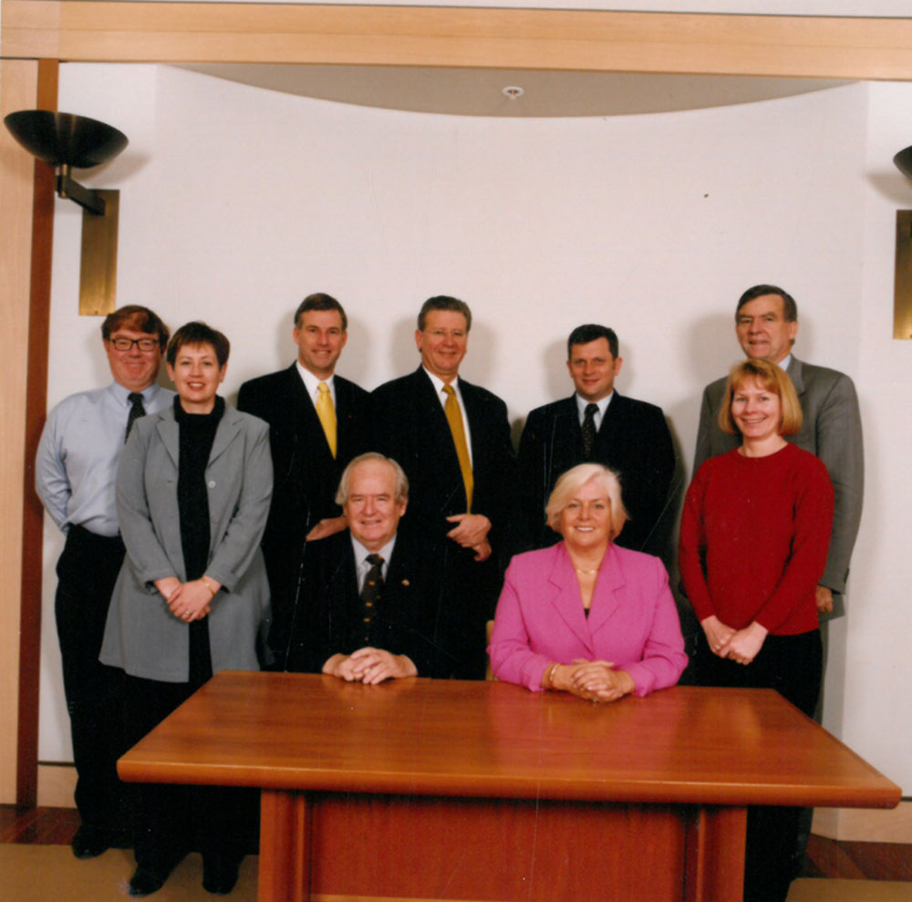 Members and staff of the Rural and Regional Affairs and Transport References and Legislation Committee, July 2002. Standing L-R: Andrew Snedden [secretary], Trish Carling [Senior Research Officer], Senators Richard Colbeck, Kerry O'Brien, John Cherry and Bill Heffernan and Lyn Fairweather [Research Officer]. Seated L-R: Senators Winston Crane and Jeannie Ferris.