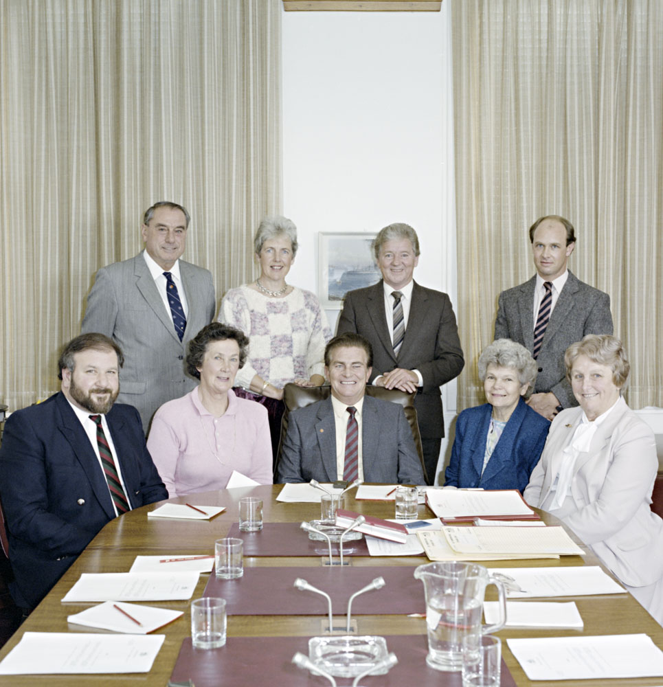 Standing Committee on Social Welfare, 1987. Standing L-R: Don Grimes, Rosemary Crowley, Bernie Kilgariff, Chris Shrosbree [Secretary]  Seated L-R: Peter Cook, Shirley Walters [Deputy Chair], Ron Elstob [Chair], Patricia Giles and Flo Bjelke-Petersen. NAA: A8746, KN9/6/87/4.