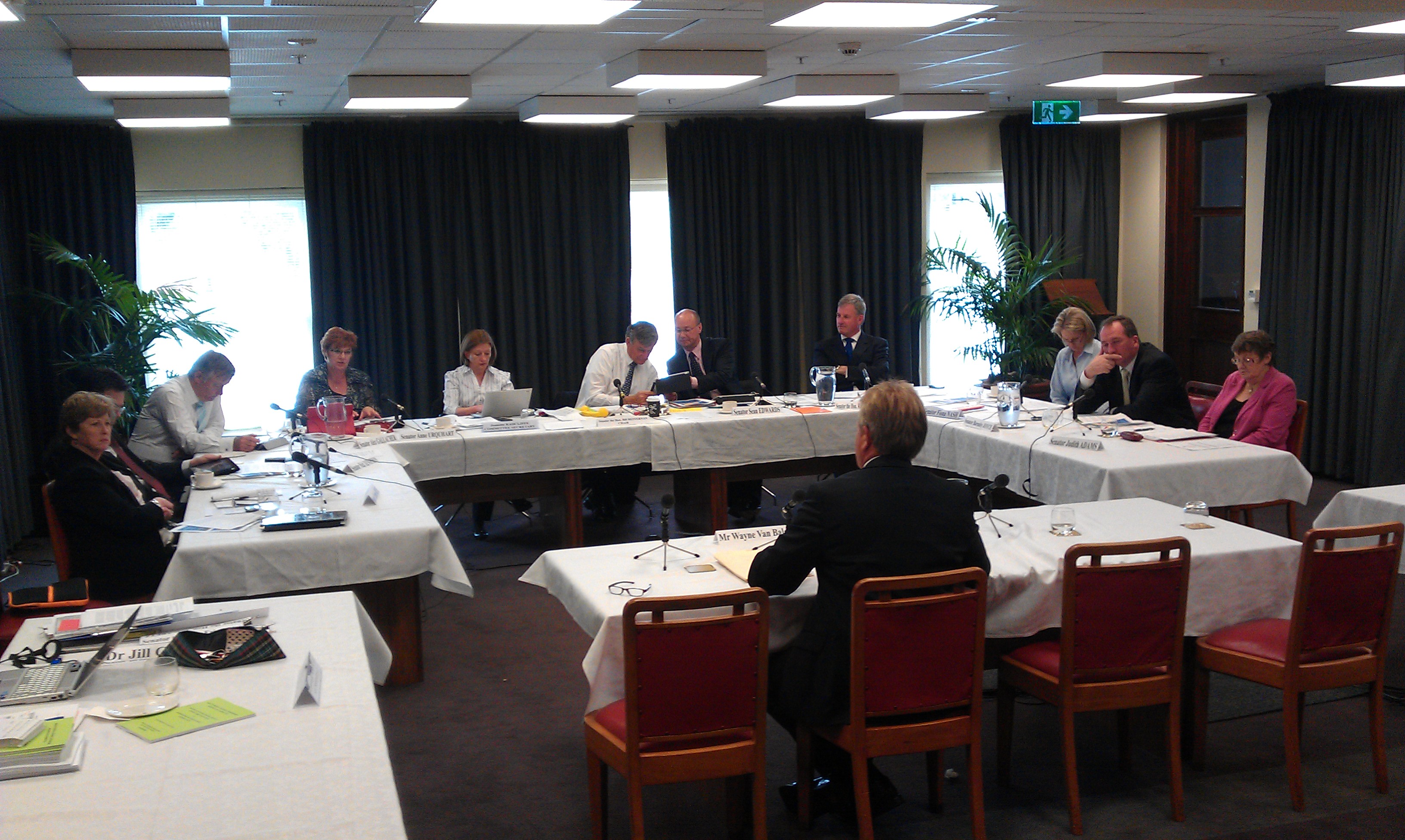 Committee hearing, Private Members Dining Room, Old Parliament House, Canberra, 16 November 2011. L-R: Senators Christine Milne, Nick Xenophon (obscured), Alex Gallacher and Anne Urquhart, Jeanette Radcliffe [Committee Secretary], Senators Bill Heffernan [Chair], Sean Edwards, Richard Colbeck, Fiona Nash, Barbaby Joyce and Judith Adams. Foreground: Wayne Van Balen [witness].