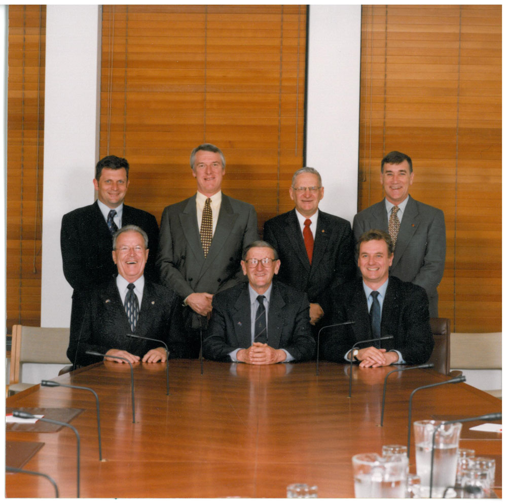 Select Committee on Superannuation and Financial Services, 2002. Standing L-R: Senators John Cherry, Grant Chapman, Geoff Buckland and John Hogg. Seated L-R: Senators Ross Lightfoot, John Watson [Chair] and Nick Sherry [Deputy Chair].