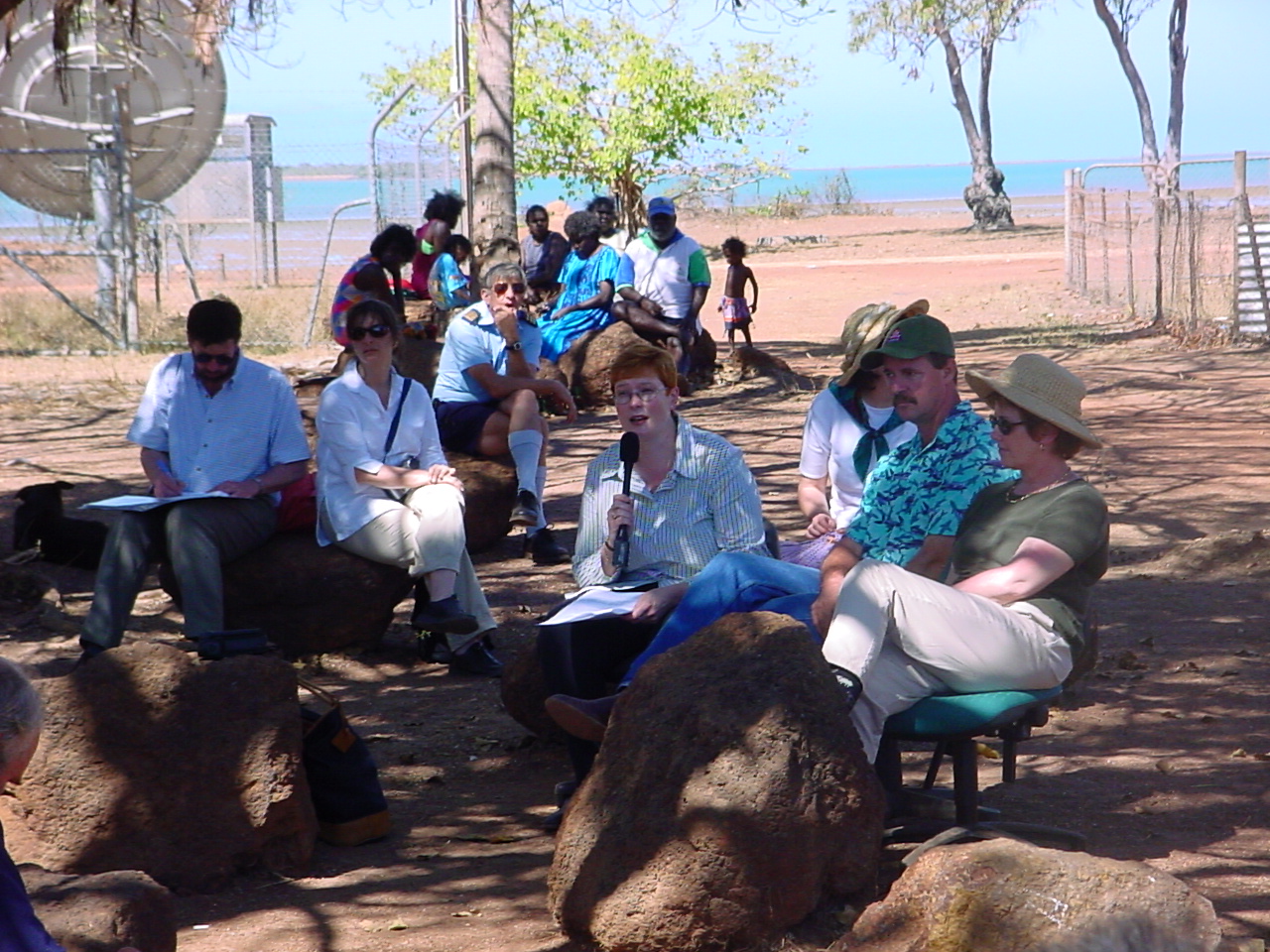 Acting committee chair Senator Marise Payne speaking to witnesses from the Warruwi and Minjilang communities at a  hearing on South Goulburn Island, NT, 11 September 2002. At right: L-R behind rock on right: Senators Ursula Stephens and Nigel Scullion.