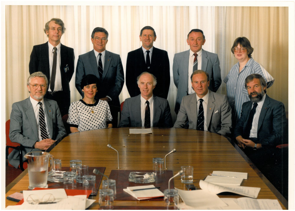 Standing Committee on Employment, Education and Training, 1987. Standing L-R: Derek Allan [Secretary], Senators Paul McLean, John Watson and Arthur Devlin, and Bev Orr [Research Officer]. Seated L-R: Senators Michael Beahan, Kay Patterson, Terry Aulich [Chair], Baden Teague [Deputy Chair] and John Devereaux.