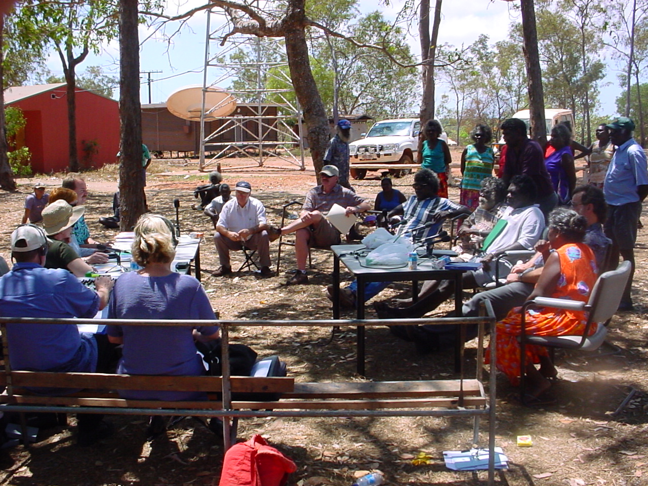 Elcho Island hearing, 11 September 2002. Seated at table on left, closest to farthest: Senators Ursula Stephens, Marise Payne [Acting Chair] and Nigel Scullion. Two Hansard editors seated with backs to camera. Witnesses seated and standing on right include Oscar Datjarrangu, Keith Djinyini, Richard Gandhuwuy, Joe Gumbula, Jeff Leggat [Council Clerk, Milingimbi Council], Roger McIvor [Manager, Marthakal Homelands Resource Centre], Jeffry Mulawa, Mike Netwon [Council Clerk, Galiwin'ku Council], Terry Yumbilil and Charles Yunupingu.