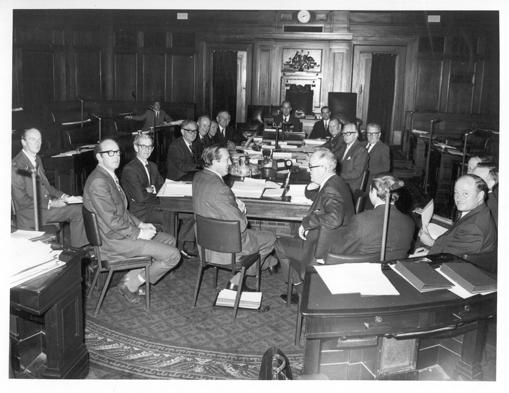 Standing Committee on Regulations and Ordinances in session in the Senate Chamber of the Provisional Parliament House, 1971. Seated at table: Senator Gordon Davidson, Bert Nicholls [Secretary], Senators Don Devitt [Deputy Chair], Ivor Greenwood, Ian Wood [Chair], Jack Little and Ellis Lawrie, others unknown.