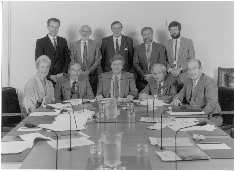 Standing Committee on Industry, Science and Technology, 1990. Standing L-R: Robert Diamond [Secretary], Senators John Coulter, David Brownhill and John Devereux, and Peter Hallahan [Research Officer]. Seated L-R: Senators Rosemary Crowley, Peter Baume, Bruce Childs [Chair], Bryant Burns and Brian Archer. Image by Peter West, Office of Government Information and Advertising.