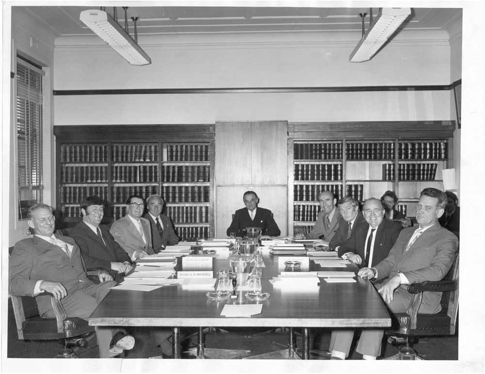 Estimates Committee D in session, November 1971. L-R: Senators Ron Maunsell, Don Jessop and Harry Cant, unknown [Secretary], Senators Condor Laucke [Chair], Michael Townley, Peter Durack, Reg Bishop and Ken Wriedt. NAA: A6180, 3/11/71/43.