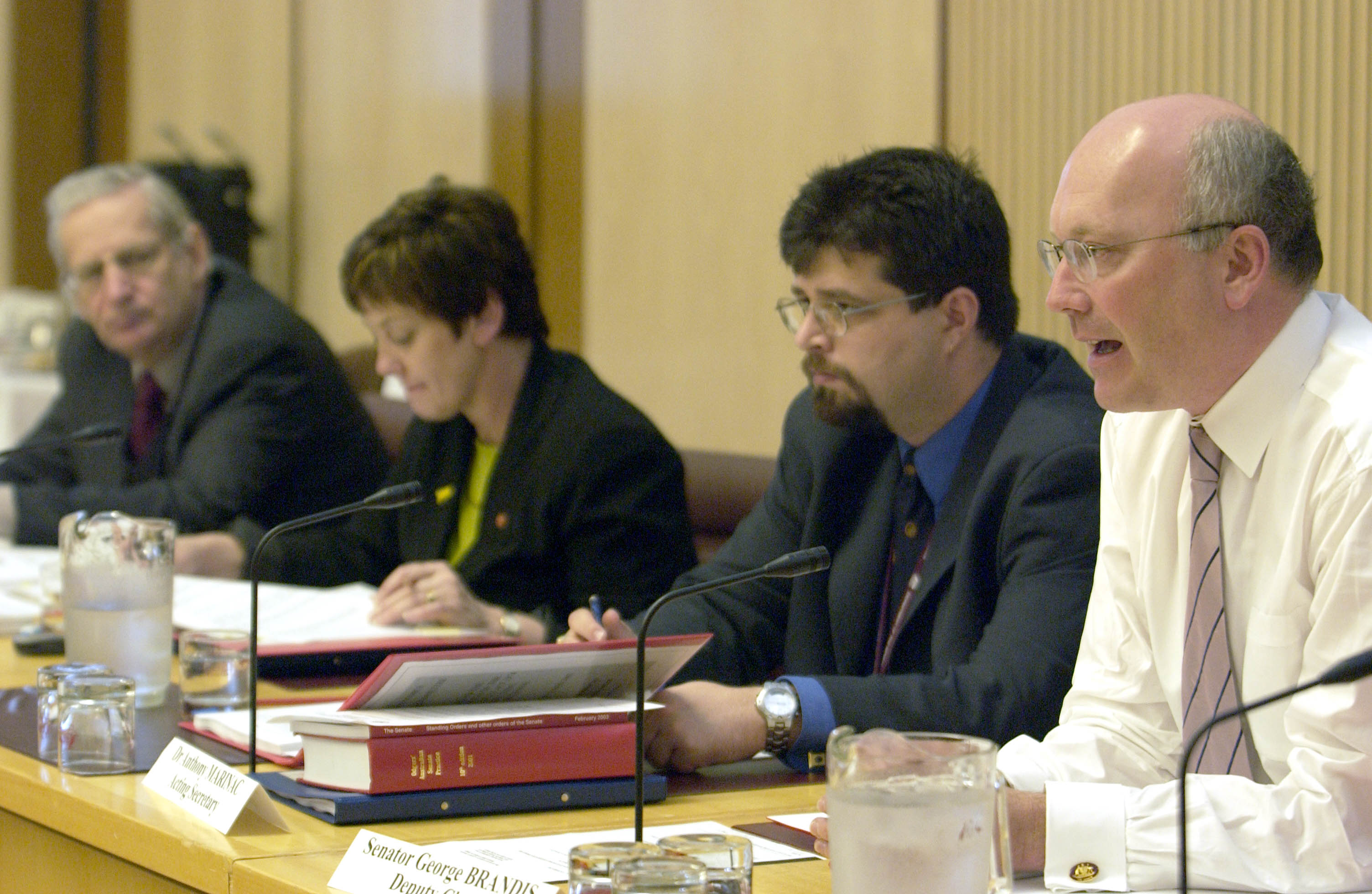 Economics References Committee deputy chair Senator George Brandis [Deputy Chair] (right) questioning witnesses, 17 October 2003. Also L-R: Senators Geoff Buckland and Ursula Stephens [Chair] and Dr Anthony Marinac [Acting Secretary]. DPS Auspic.