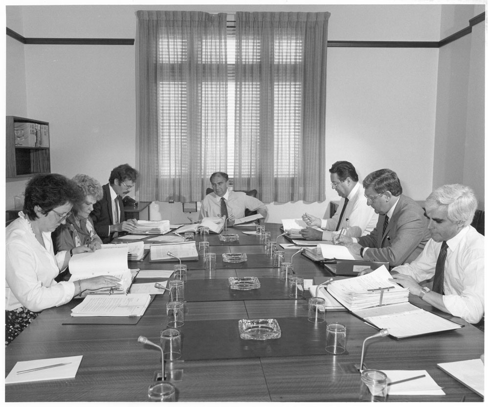 Standing Committee on Regulations and Ordinances in session, 31 March 1987. L-R: Senators Amanda Vanstone and Patricia Giles, Peter O’Keeffe [Secretary], Senators Barney Cooney [Chair], Reg Withers, Austin Lewis [Deputy Chair] and John Coates. NAA: A6180, 31/3/87/63.