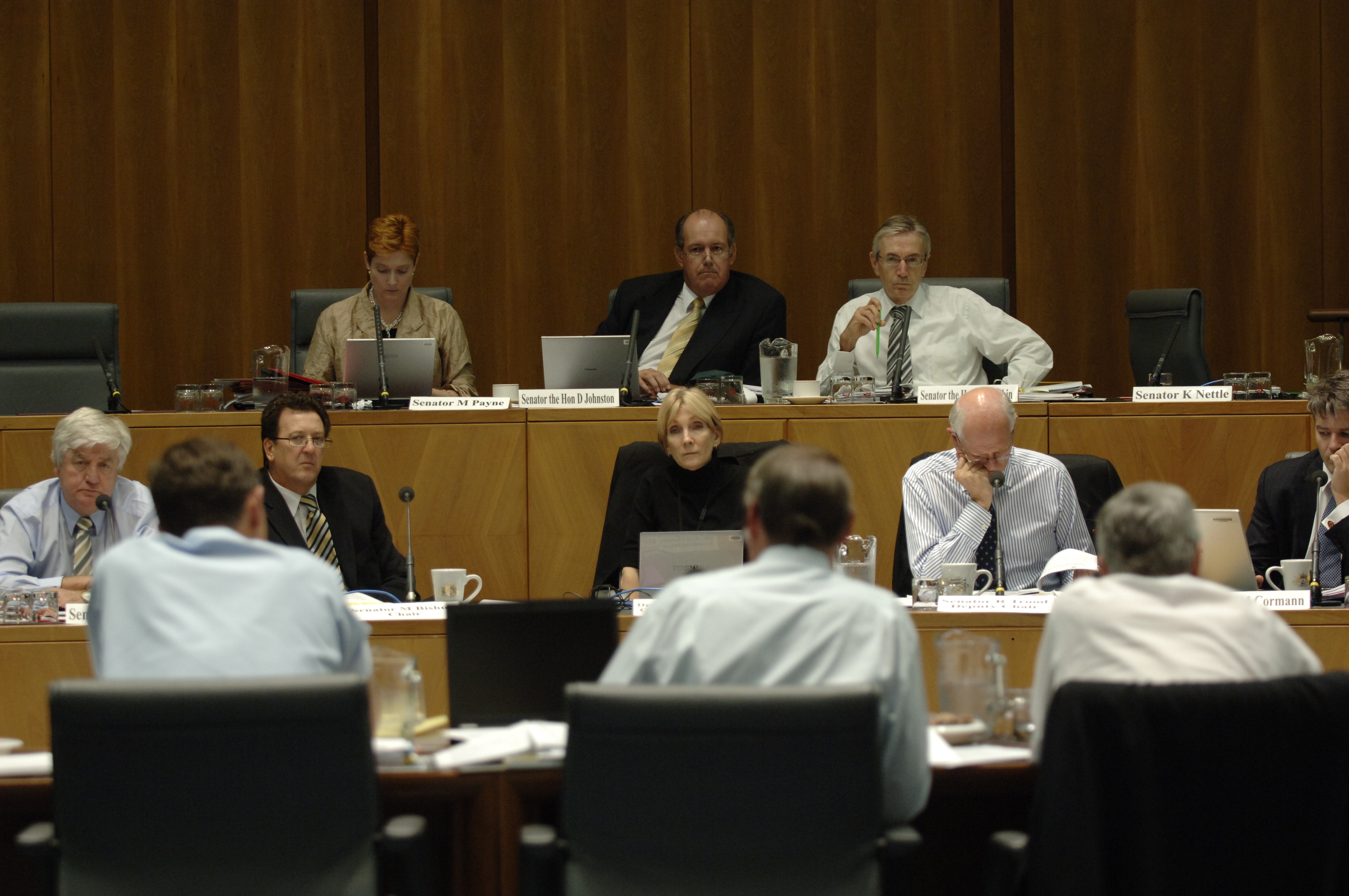 Standing Committee on Foreign Affairs, Defence and Trade at an additional estimates hearing, 20 February 2008. Top row facing camera L-R: Senators Marise Payne, David Johnston and Nick Minchin. Bottom row facing camera L-R: Senators Michael Forshaw and Mark Bishop [Chair], Dr Kathleen Dermody [Secretary], Senators Russell Trood [Deputy Chair] and Mathias Cormann. DPS Auspic.