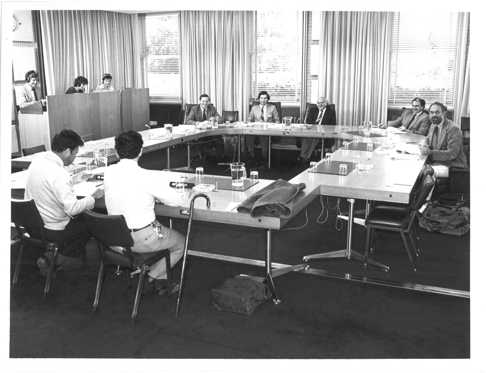 Select Committee on Animal Welfare hearing evidence from witnesses at a public hearing of its inquiry into kangaroos, 14 May 1986. Seated facing camera L-R: Senator David Brownhill, Paul Barsdell [Secretary], Senators George Georges, Barney Cooney and Norm Sanders. Seated with backs to camera L-R: Witnesses Bob Spanswick [General Secretary, Customs Officers Association of Australia] and B.J. Wallett [Consultant, RSPCA].